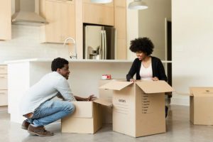 Couple en train de faire ses cartons de déménagement dans la cuisine